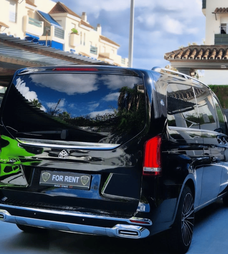 Black Mercedes-Benz Maybach luxury van available for rent parked in front of a residential building.