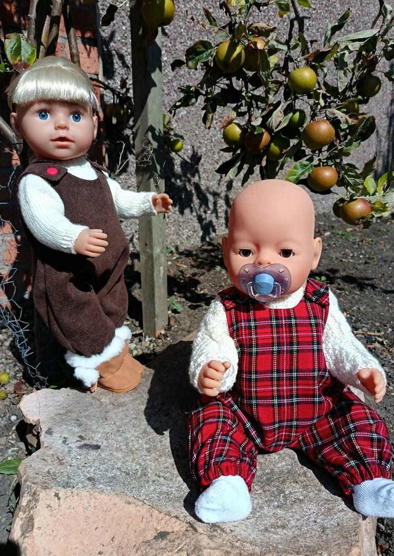 Zapf Baby Born and Big sister dolls dressed for autumn next to apple trees