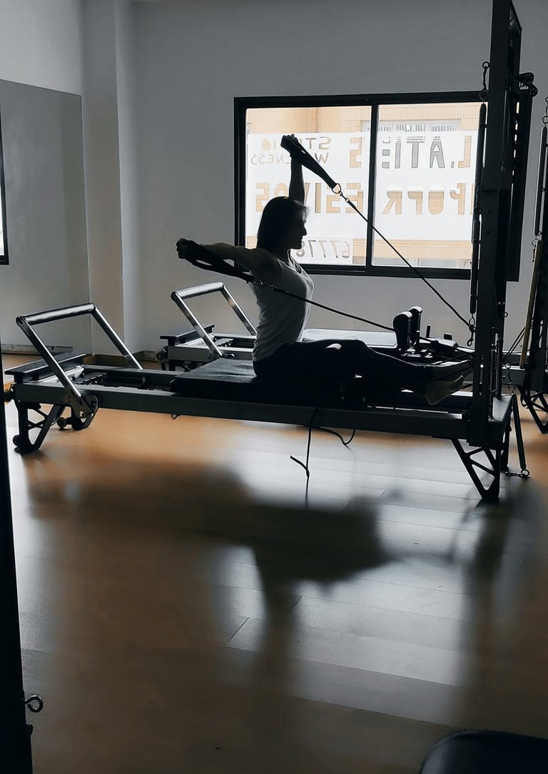 Pilates coach ejecutando un ejercicio de fuerza, utilizando los principios del método Pilates