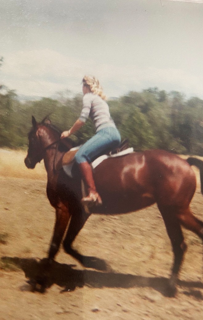 Nancy Jo riding her horse in a field