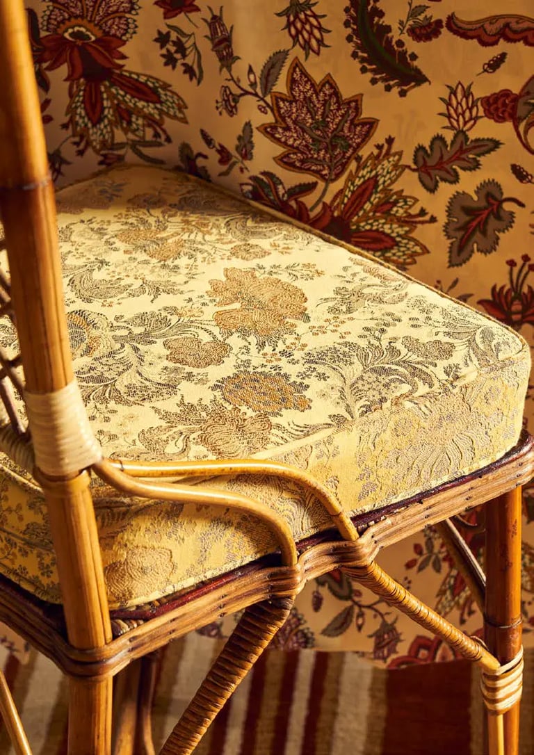 Chaise avec un coussin recouvert d'un coussin au tissu jaune et floral