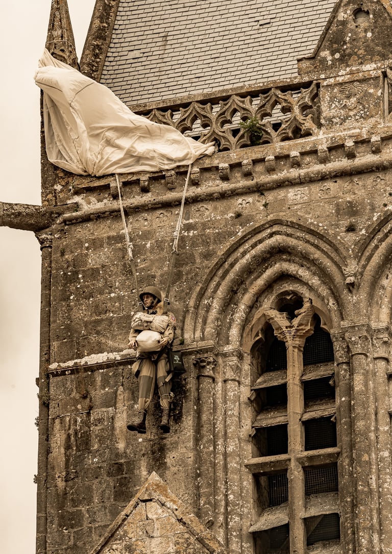 Réplique de John Steele, parachutiste américain, suspendue au clocher de l'église de Sainte-Mère-Église, symbole d'héroïsme.