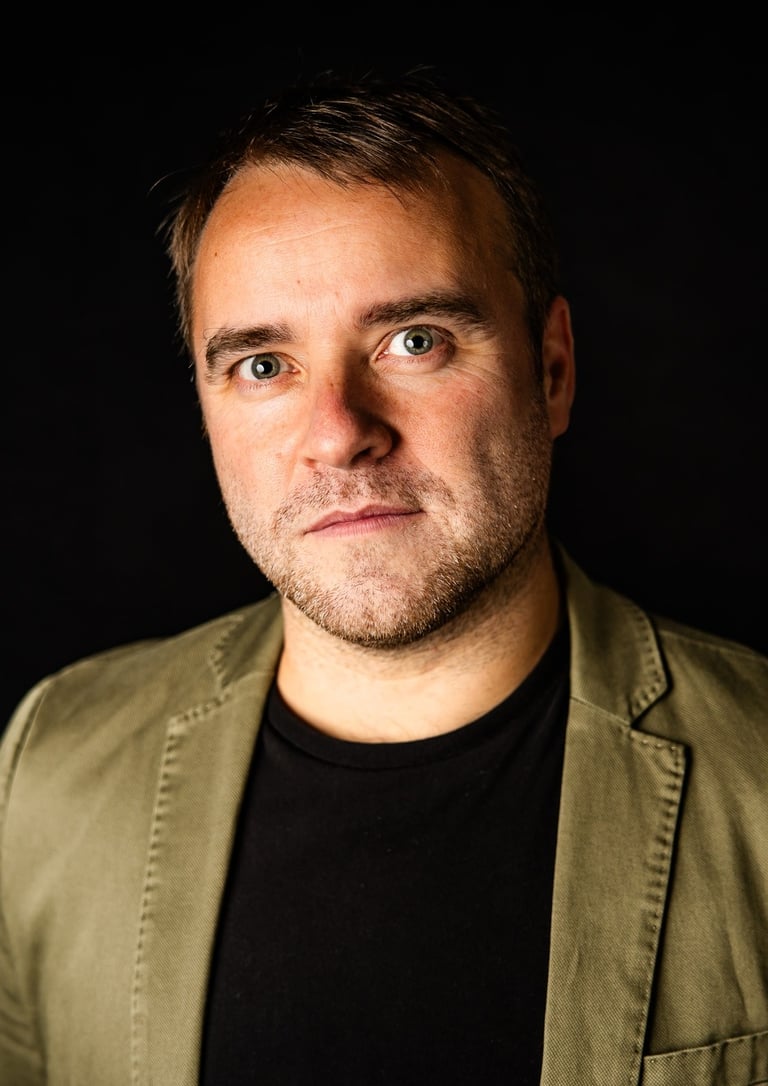 a man in a jacket and a black shirt