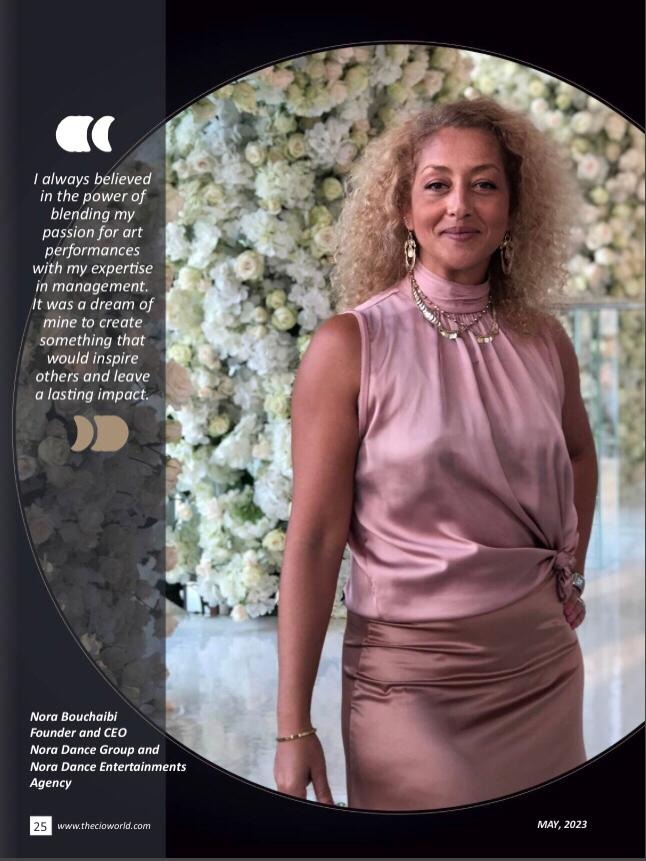 Nora Bouchaibi, Founder and CEO of Nora Dance Group, posing in a pink silk top against a floral backdrop.