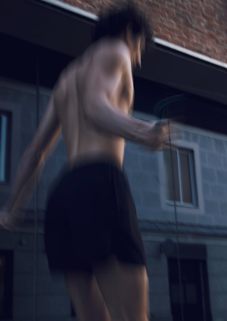 a man in a black shorts and a white shirt jumping the rope