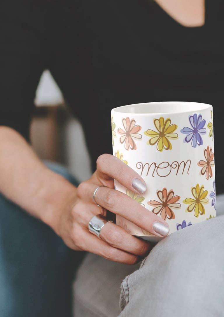 A woman holding a floral mug with 'mom' written on it, perfect for Mother's Day gifts by Mara Branco