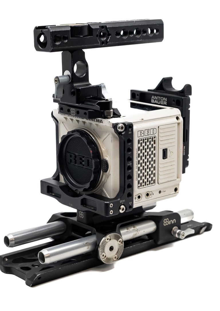 Close-up of a RED camera mounted on a rig with adjustable support rods, ideal for professional filmmaking.