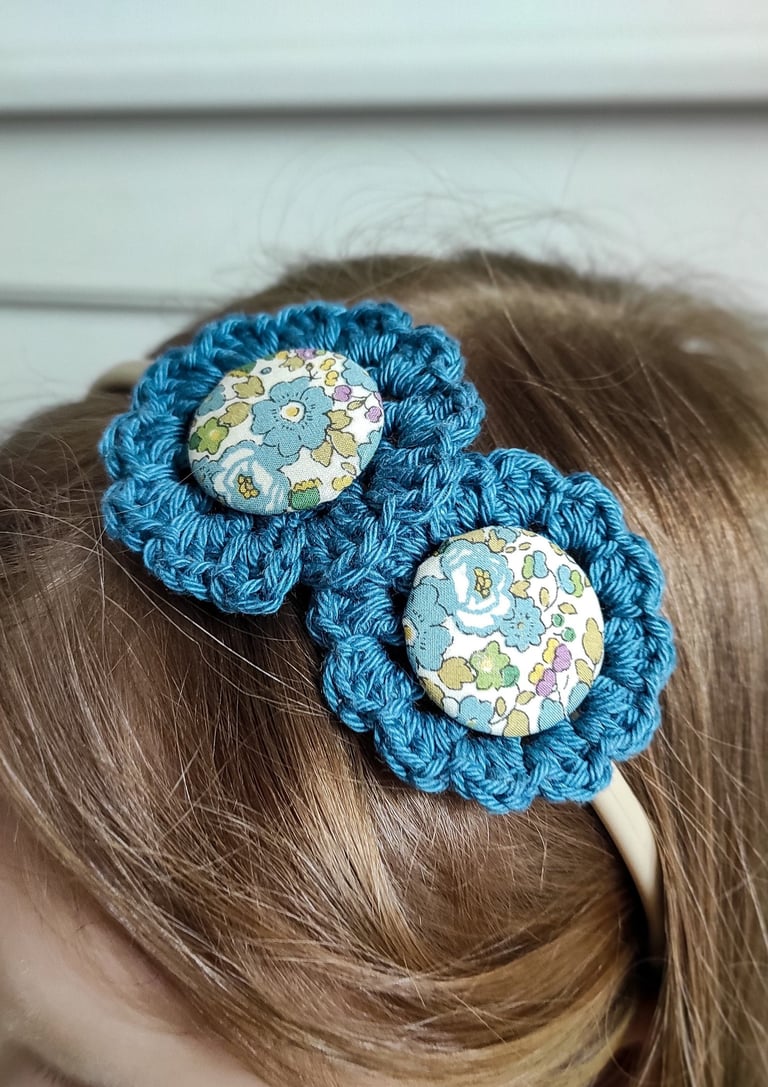 opaska do włosów z turkusowymi kwiatami na głowie dziewczynki z jasnymi włosami