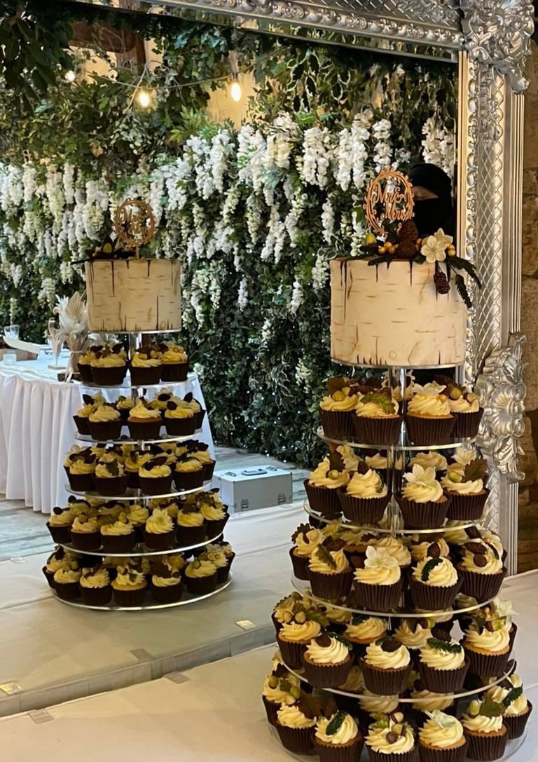 a wedding cake with cupcake tower on a table