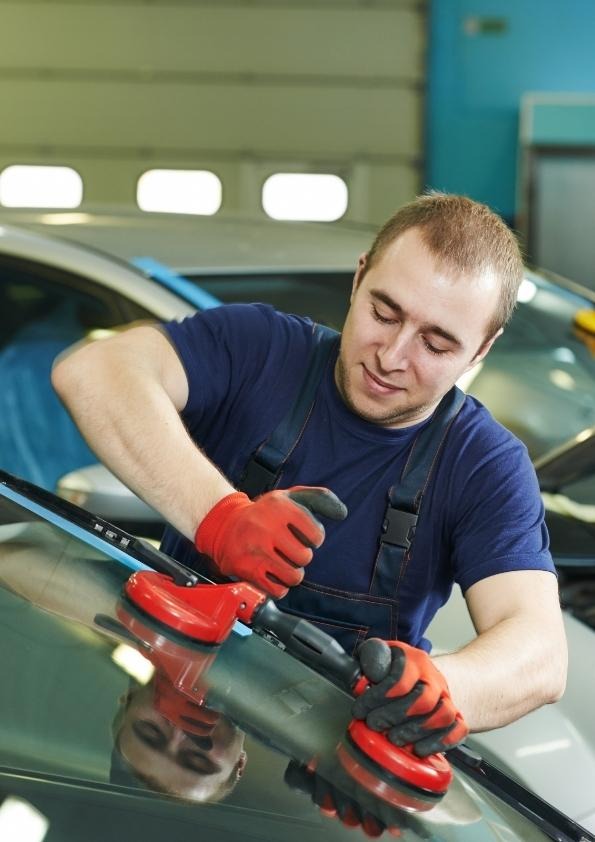 a man in a blue shirt is using a machine to polish a car