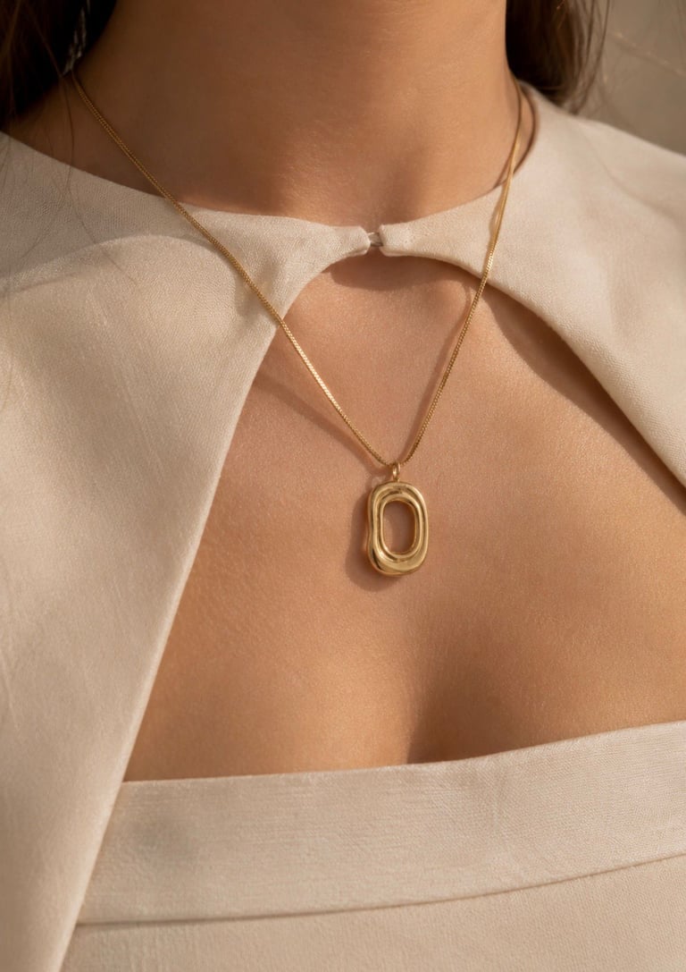 Gold pendant necklace styled with a cream off-shoulder top in warm natural light.