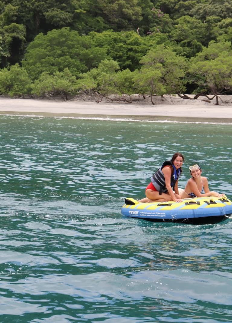 Friends tubing in turquoise waters during catamaran tour in Papagayo Gulf