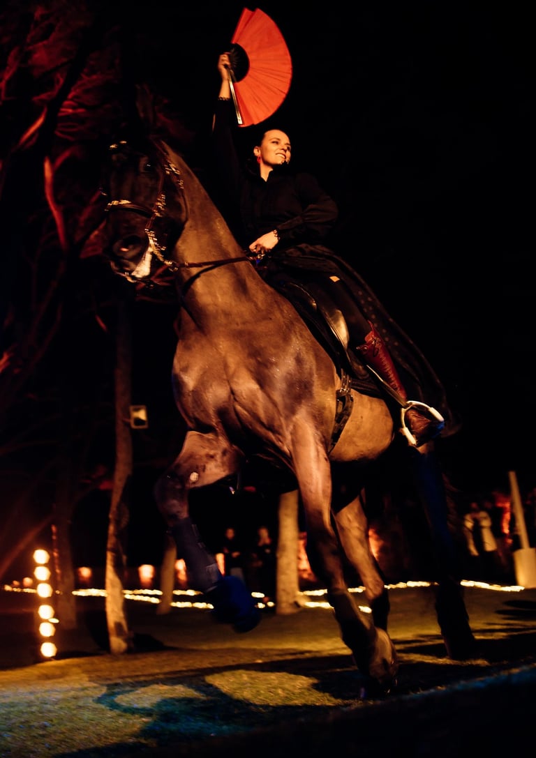 Bride on horseback with red fan at night wedding show