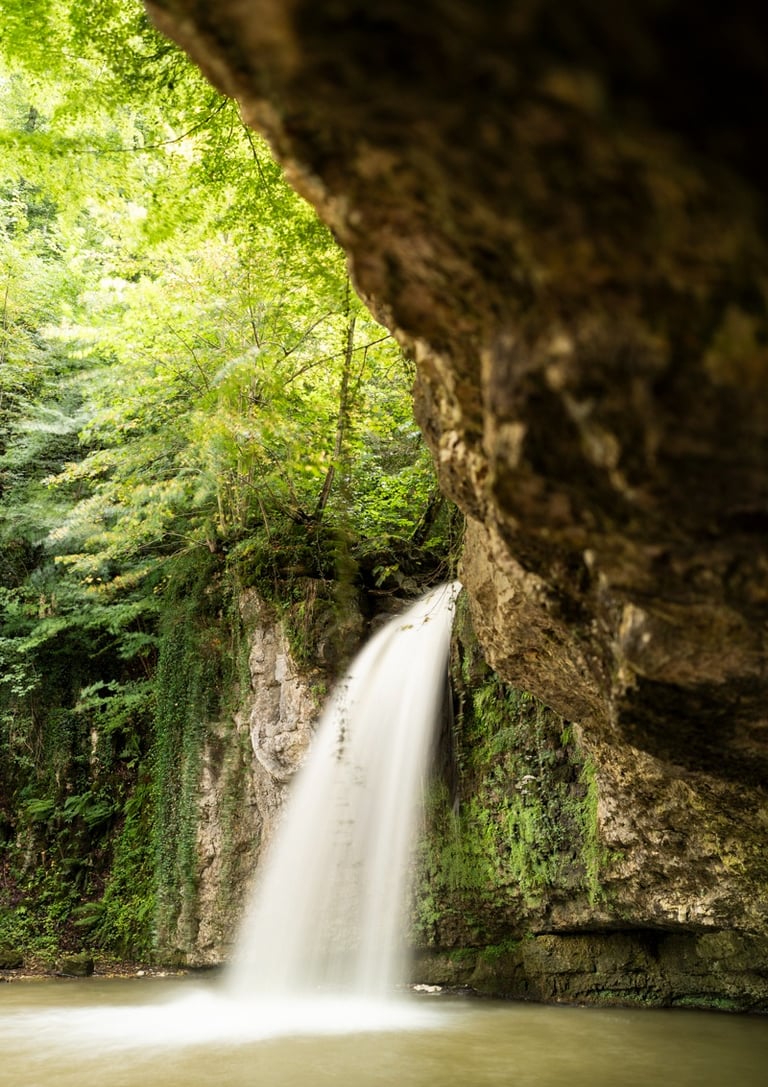 a waterfall in a cave in the woods