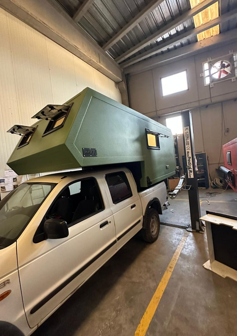 un vehículo pick up verde con cabina camper