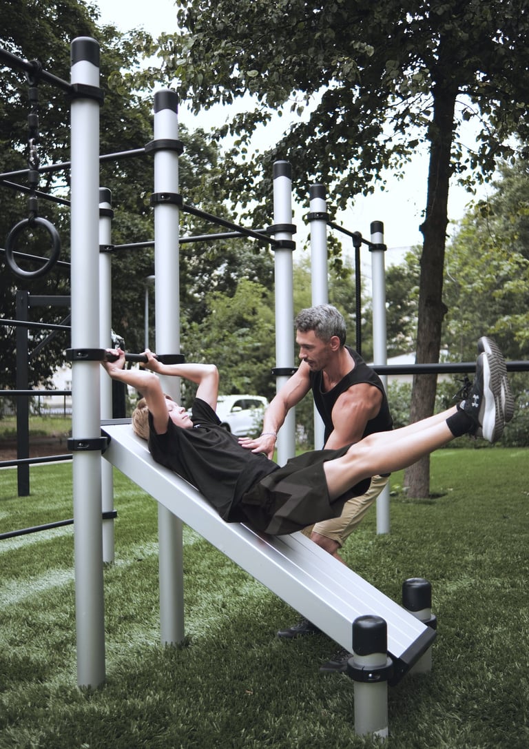 Enfant s’entraînant sur un équipement Kenguru Pro Kids Workout avec l’aide d’un coach.
