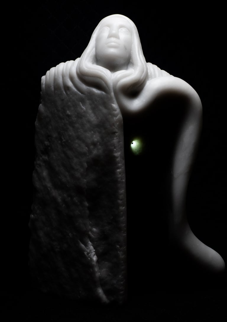 White marble sculpture of a hooded figure emerging from a rough stone block against a black background.