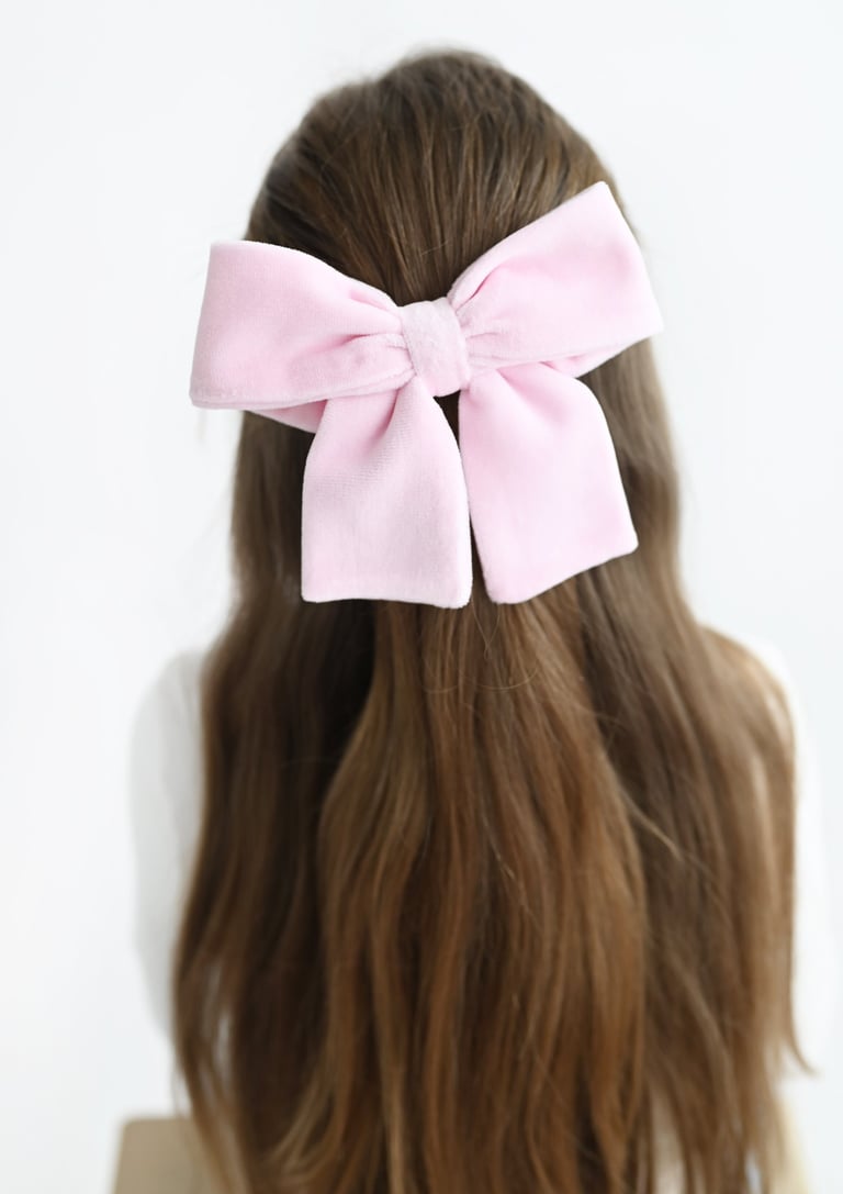 a woman with a pink bow tie on her hair