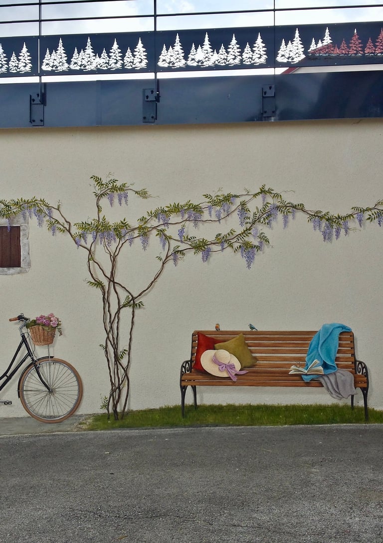 Un vélo, une glycine, un banc, des oiseaux, un livre et une fenêtre en trompe-l'oeil, ces décors peints animent une façade ex