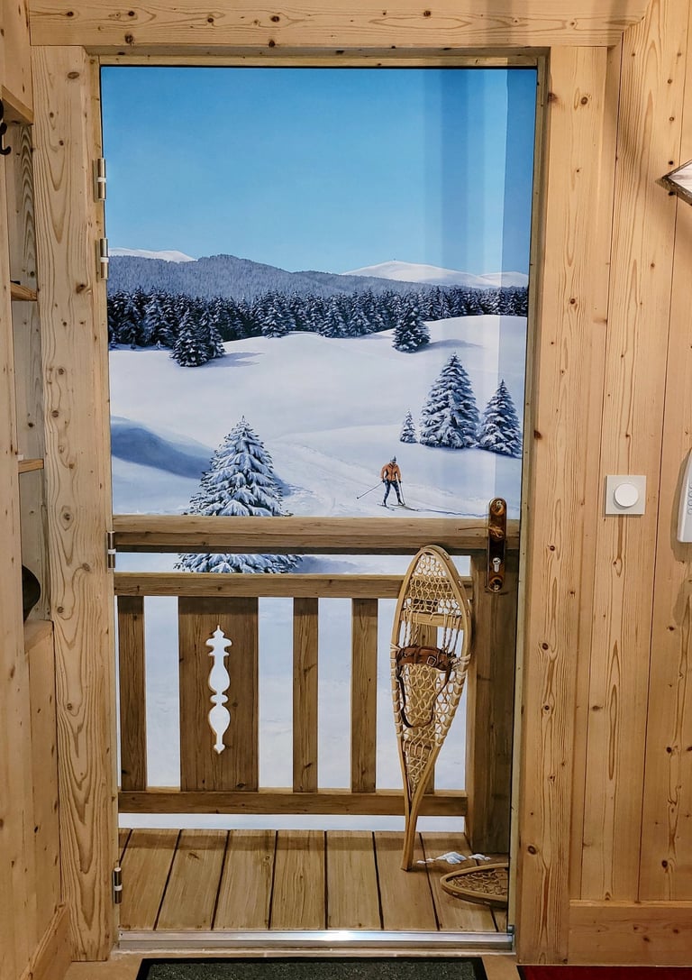 Une porte d'entrée basique se transforme en décor hivernal jurassien. Ce décor habille une porte de service disgracieuse.