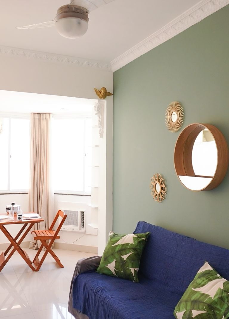 a couch with pillows and a table with chairs