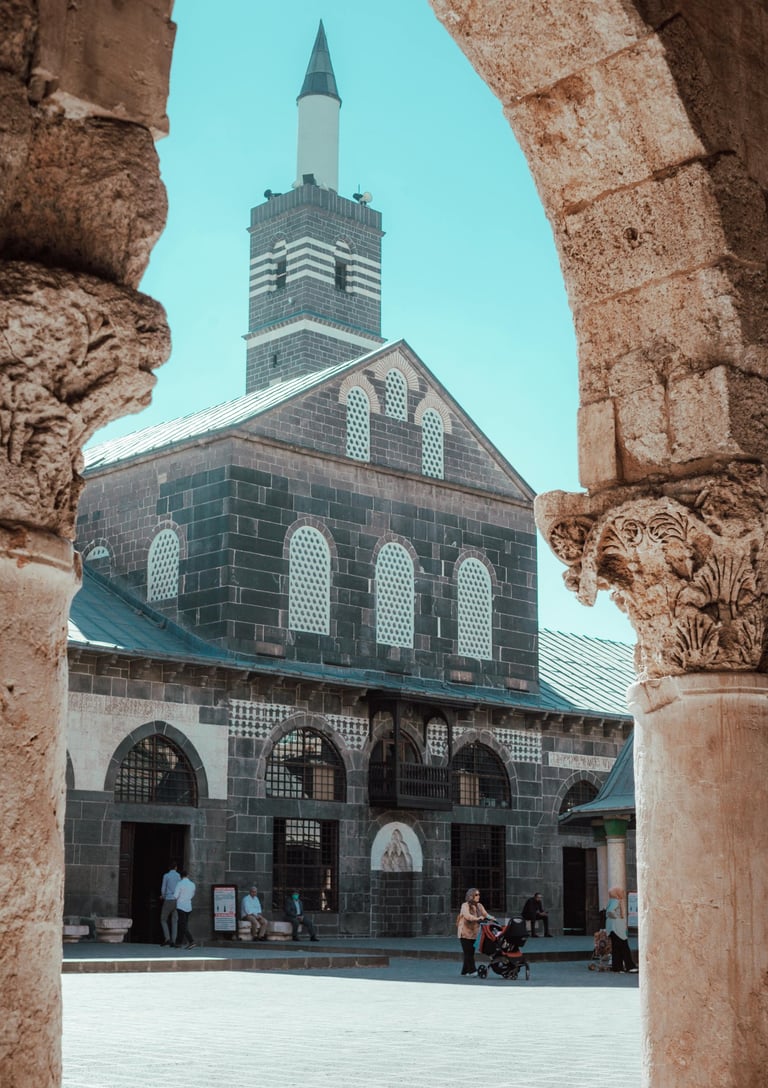 The Great Mosque of Diyarbakir framed by an ancient stone archway in Turkey.