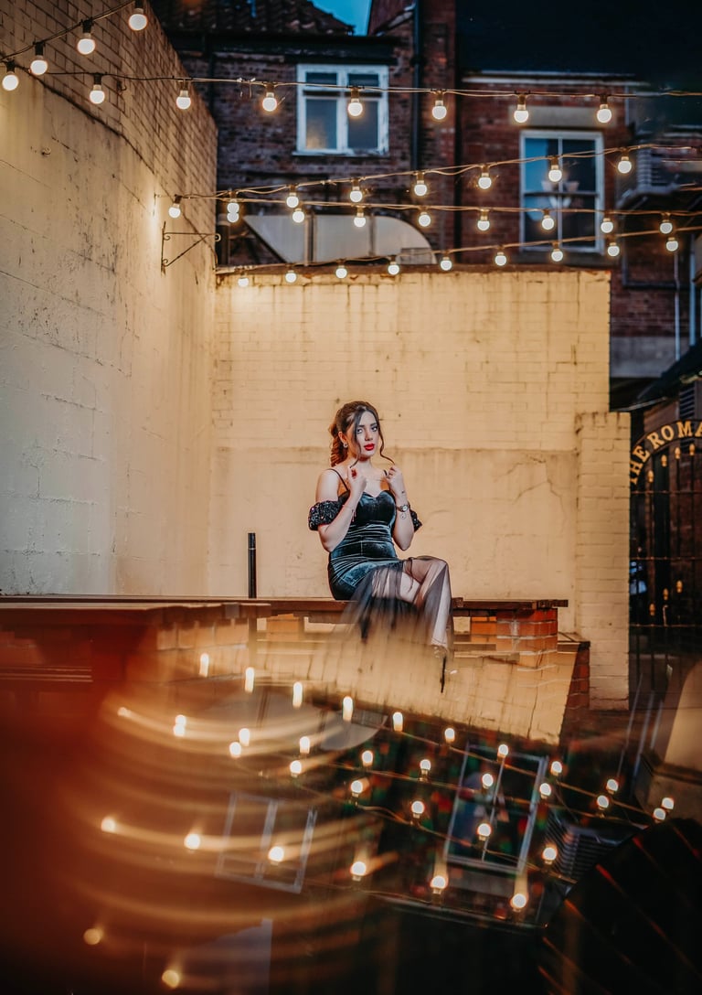 Bride posing under string lights in a York courtyard, captured by Fred Art Studio.