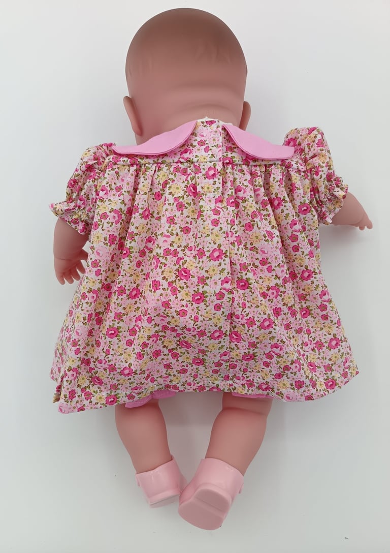 Back view of pink floral dress on Berenguer twin