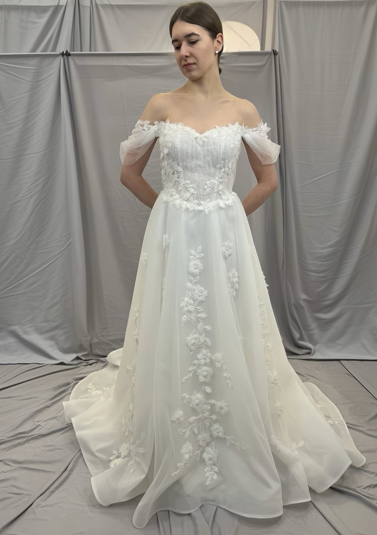 a woman in a wedding dress standing in front of a white backdrop