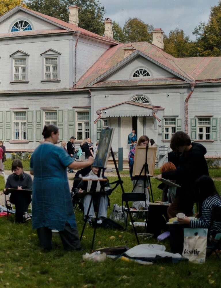 Artists painting during an outdoor landscape class in Italy.