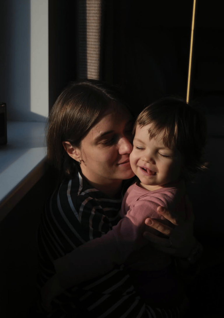 mother and toddler hugging with closed eyes in Geneva