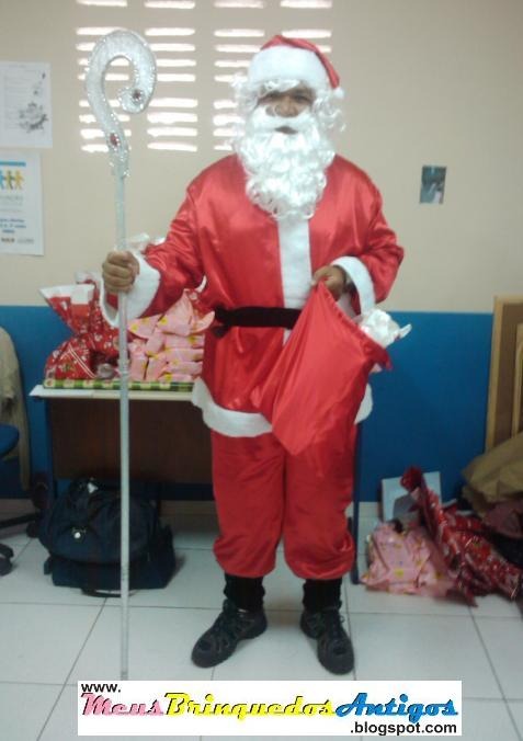 Atuando como Papai Noel na distribuição de brinquedos em escolas públicas.