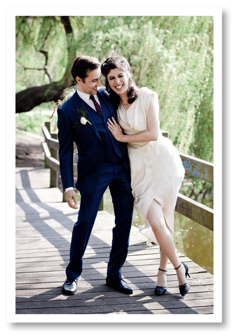 Laughing married couple on a wooden bridge.