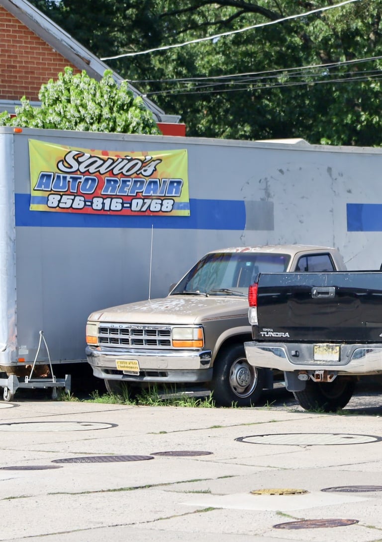Old banner of Savio's auto repair on a trailer