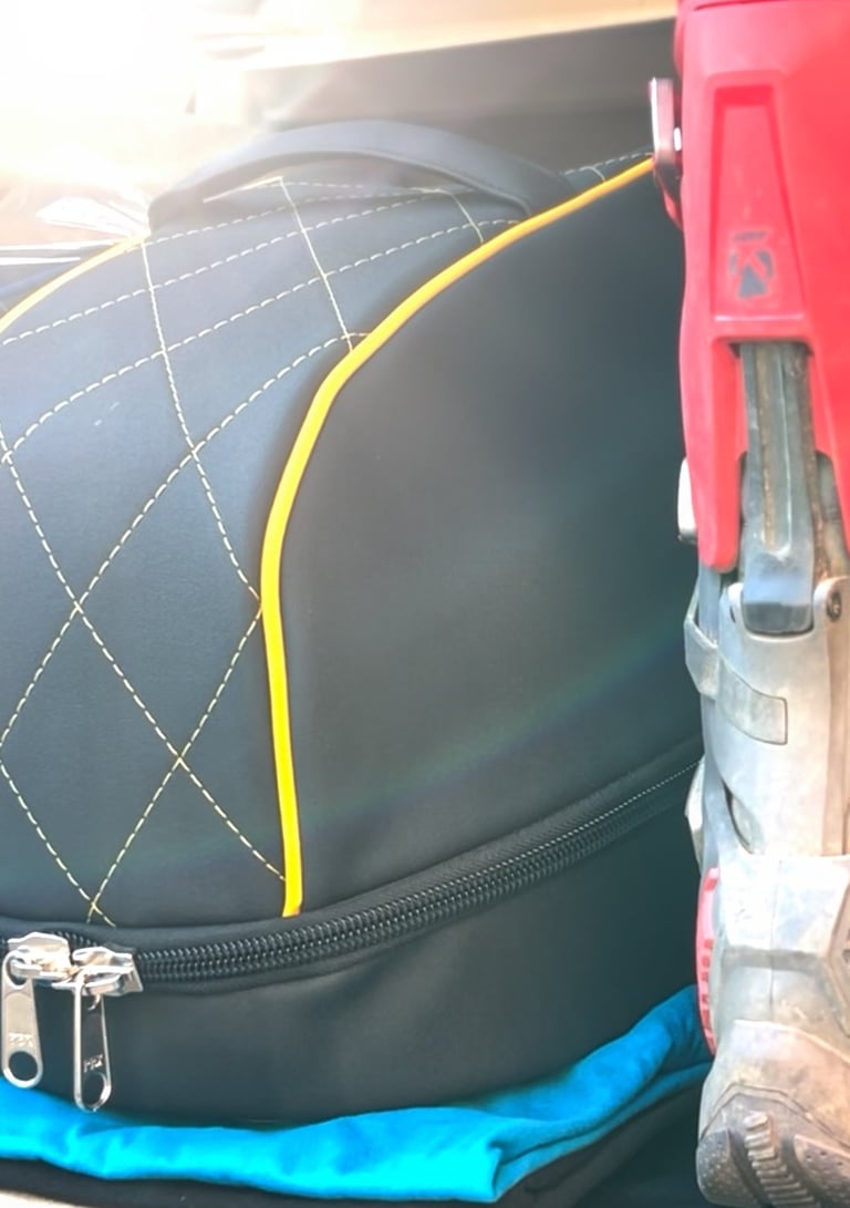 a pair of mx boots and a luxury helmet bag