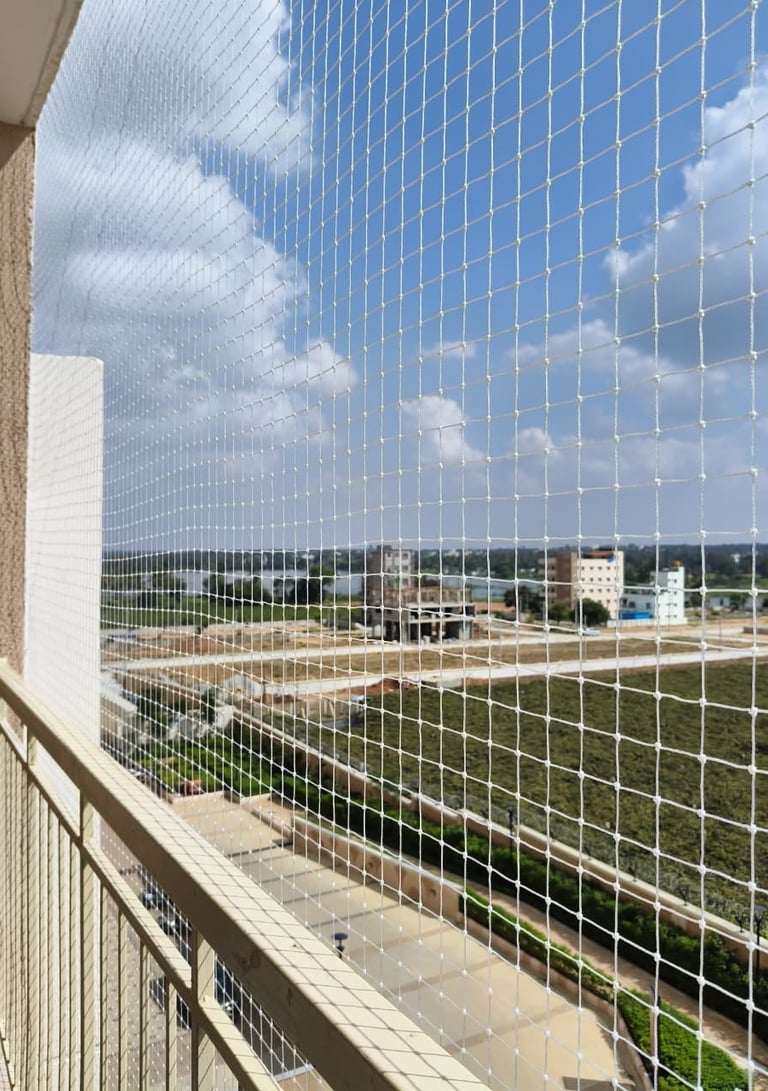 Close-up of a sturdy balcony safety net securely installed on a Jalahalli apartment balcony.