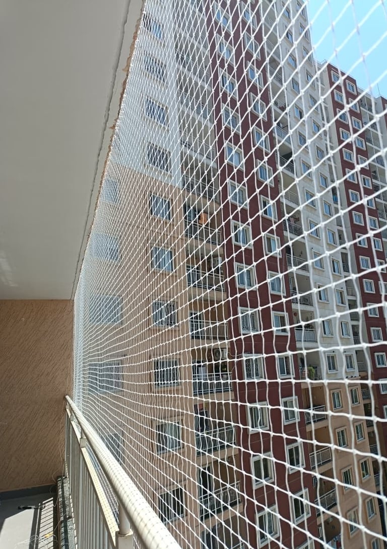 Close-up of a securely installed balcony safety net in a sunny Electronic City apartment.