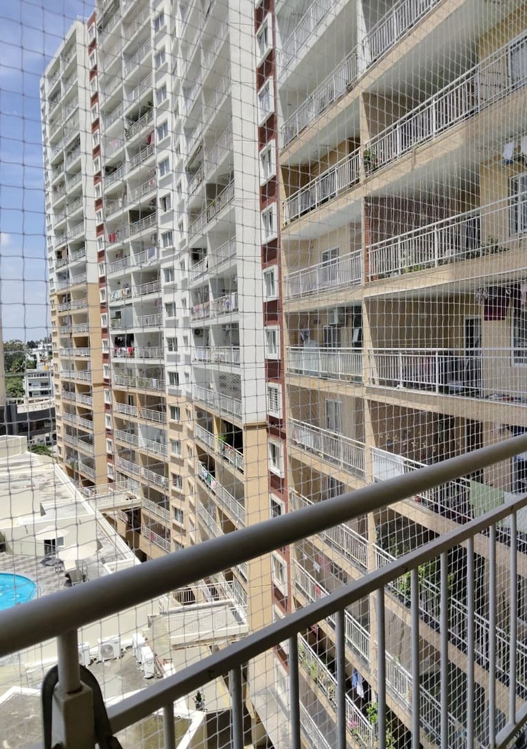 Close-up of a freshly installed pigeon safety net on a balcony in Hurlur, Bengaluru, showing the fin