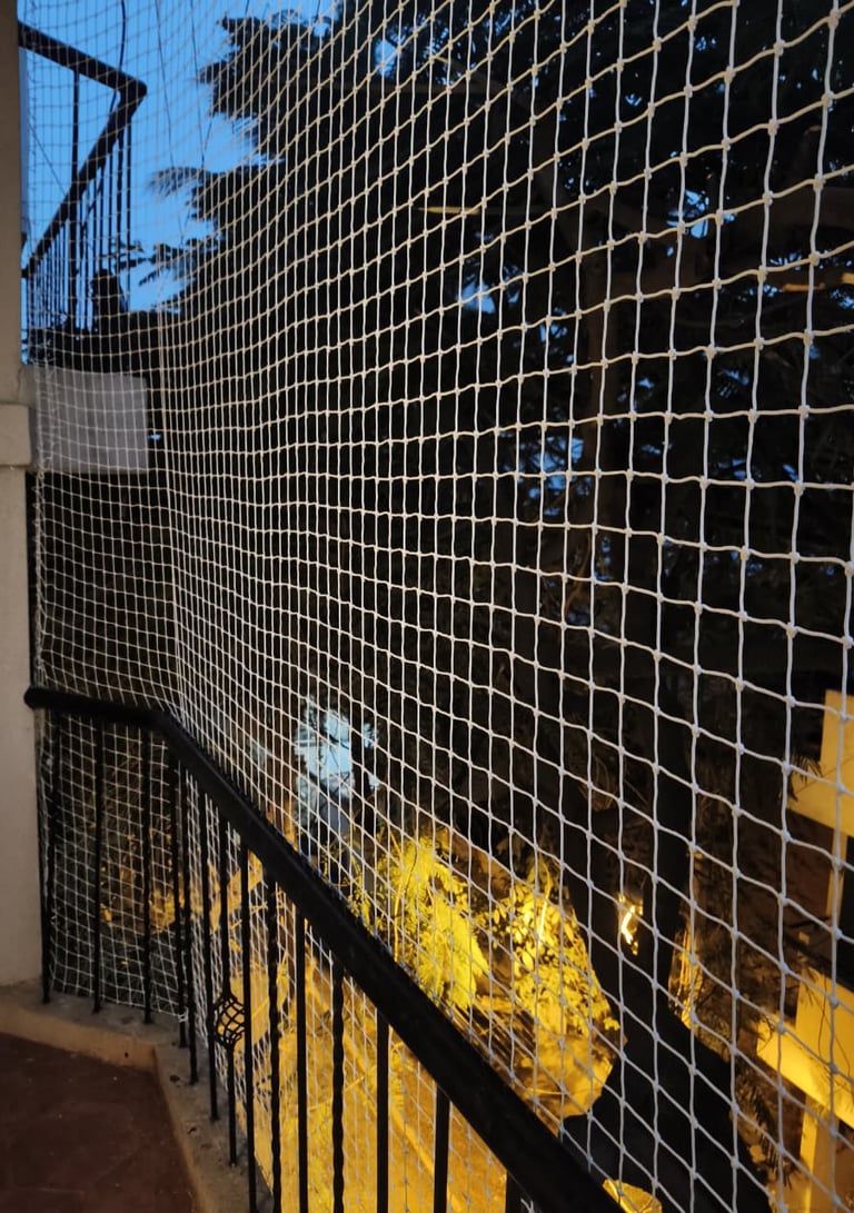 Close-up of a securely installed balcony safety net in a Sadashivanagar apartment, sunlight filterin