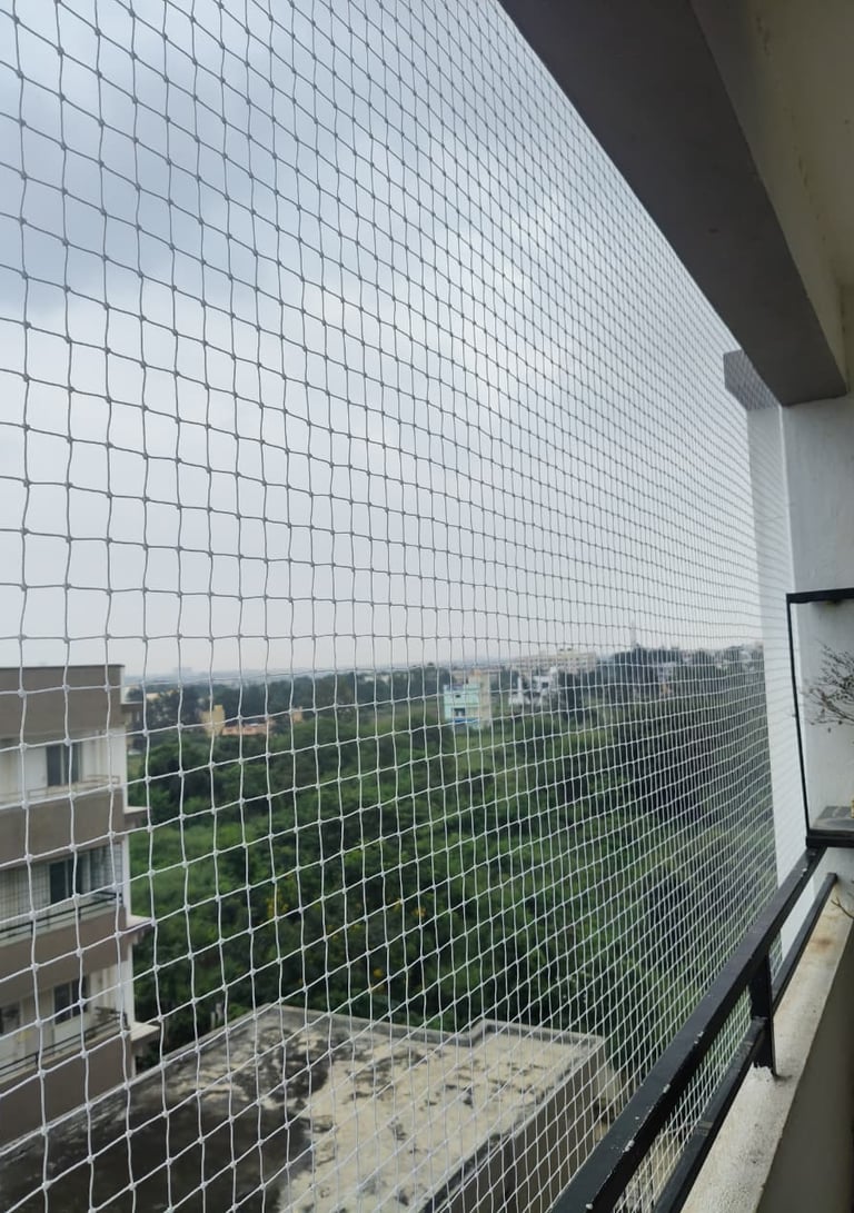 Close-up of a securely installed balcony safety net on a high-rise apartment in Bengaluru.