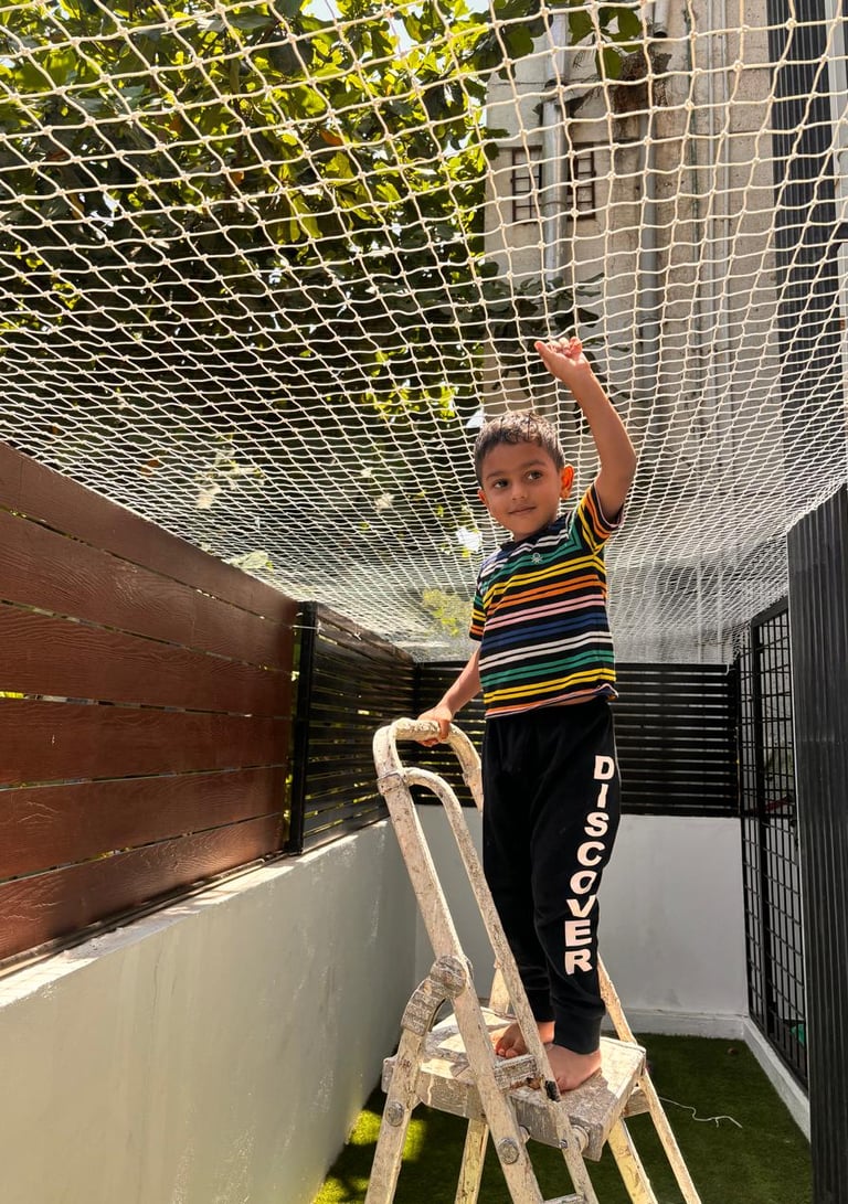 Close-up of a securely installed balcony safety net on a high-rise apartment in Ahmedabad, showing t