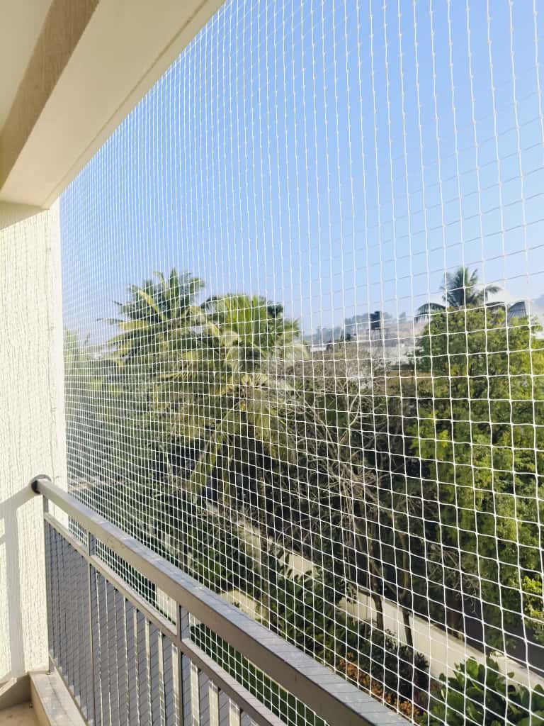 Close-up of durable anti-pigeon netting installed on a balcony in Thoraipakkam.