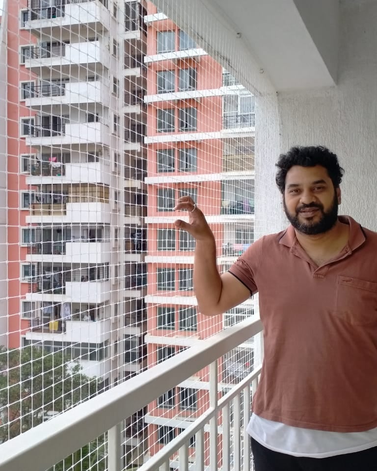 Close-up of a securely installed balcony safety net protecting a child playing nearby.