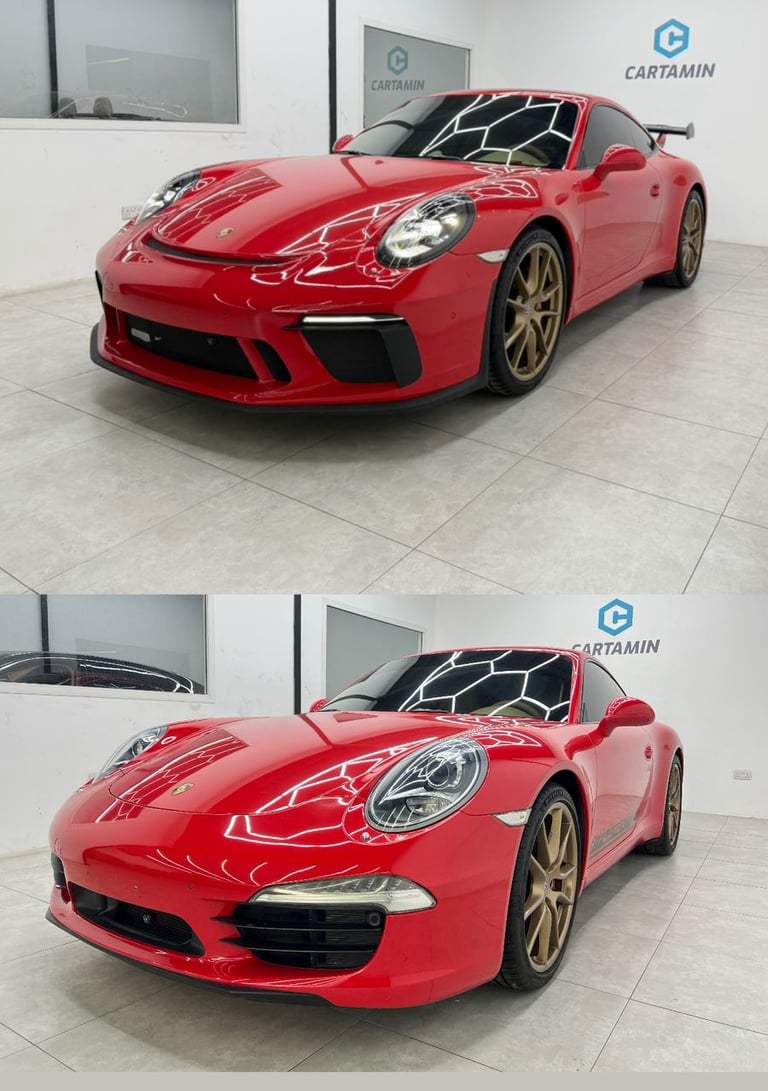 A vibrant red Porsche 911 luxury sports car with gold wheels parked in a modern showroom.