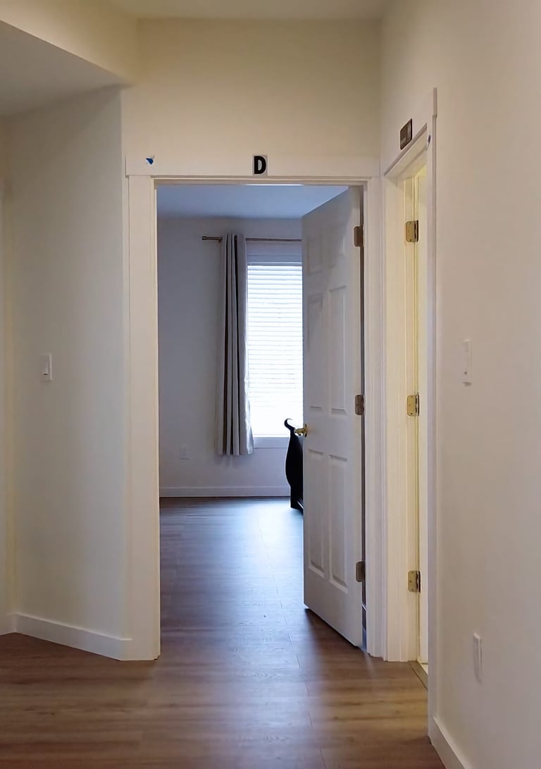 Private suites in adult family home with bed, seating area, and personal storage for resident comfort.