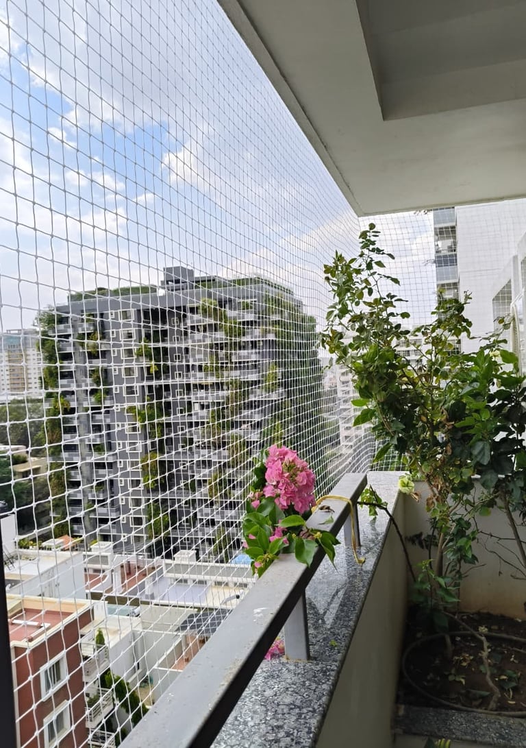 Close-up of a sturdy balcony pigeon net securely installed on a window in Nungambakkam, Chennai.