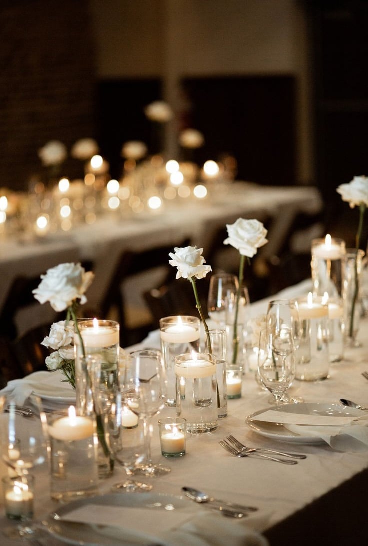 Mesas para evento decorada con manteles, llena de platos, tenedores, y otra decoracion
