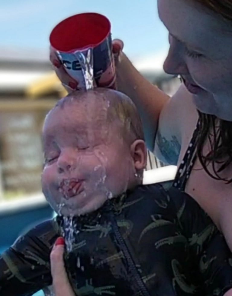 a baby is being held by a woman in a bathing suit