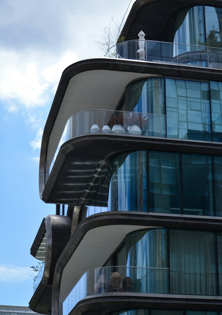 edificio moderno, lineas curvas, balcones con barandas vidrio, ventanales esquinas redondeadas