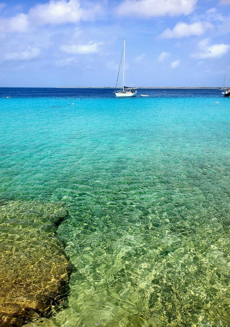 Bonaire waters with small sailboat. Crystal clear waters were scuba and snorkeling are world renown